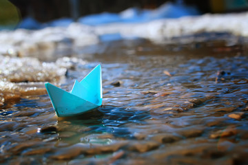 Fototapeta na wymiar tinted photo paper boat on spring street