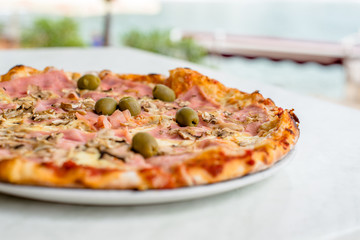 Pizza Margherita on white tablecloth closeup shot