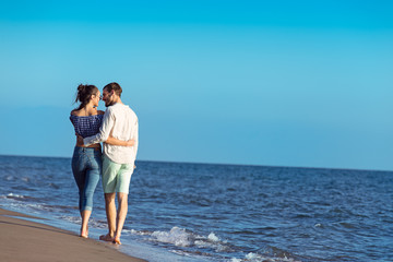 Couple walking on beach. Young happy interracial couple walking on beach.