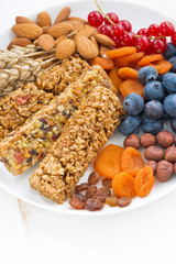 cereal muesli bars, fresh and dried fruit on a plate, vertical