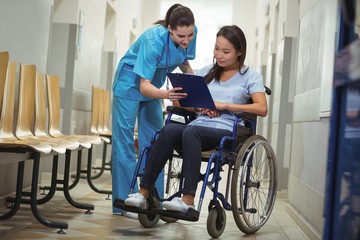 Female nurse assisting patient over clipboard