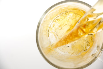 Pouring green tea into glass cup, isolated on white