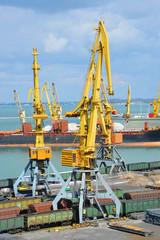 Bulk cargo ship and train under port crane