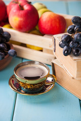 coffee in a cup, grapes and apples on a table, selective focus, copy space
