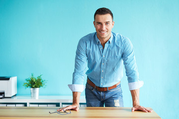 Happy man leaning on a table