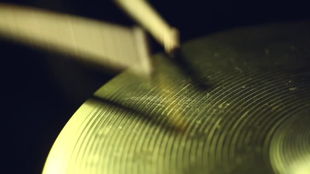 Close up footage of two drum sticks hitting a cymbal.