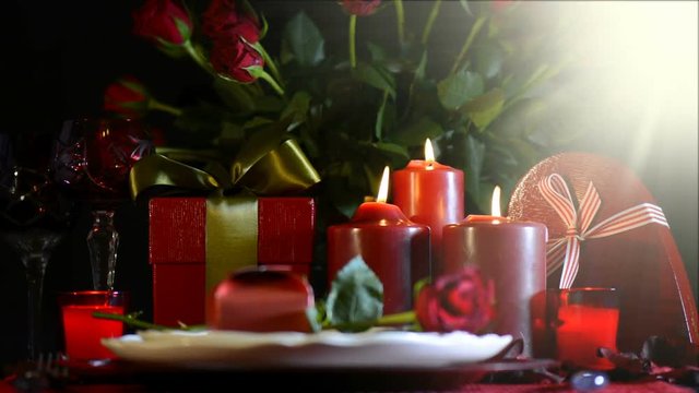 Valentine romantic table setting close up with lens flare against a black background, with mid focus.