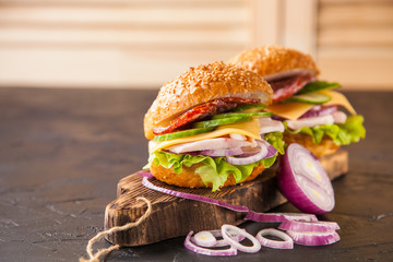 hamburger with ham and vegetables on a table, selective focus, copy space, dark photo
