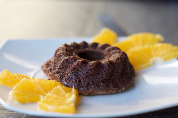 close up of a sweet chocolate souffle, soft focus on  orange decoration