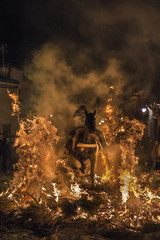 Caballos saltando hogueras de fuego en la noche de las luminarias para celebrar el día de San...