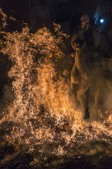 Caballos saltando hogueras de fuego en la noche de las luminarias para celebrar el día de San Antón, patrón de los animales en el pueblo de San  bartolomé de Pinares en España