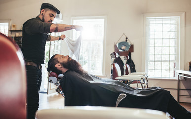 Barber taking care of client in barbershop © Jacob Lund