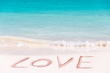 Love written on the white sand of an idyllic beach