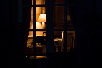Lamp in the darkness. Light in room at night. Every house has its mystery.