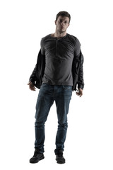 Fototapeta premium Back lit silhouette of casual man taking off jacket looking at camera. Full body length portrait isolated over white background.