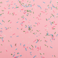 pattern of colorful sprinkles topping on pink background