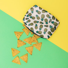 The nachos fall out of women's fashion clutch or handbag. Minimalism and creativity.