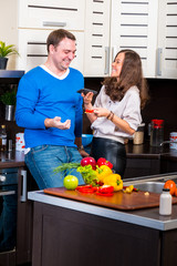 Young couple having fun in the kitchen preparing dinner