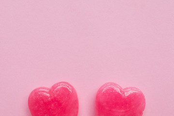 Fototapeta premium two Pink Valentine's day heart shape lollipop candy on empty pastel pink paper background. Love Concept. Knolling top view. Minimalism colorful hipster style.