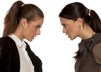Two young angry women watch each other