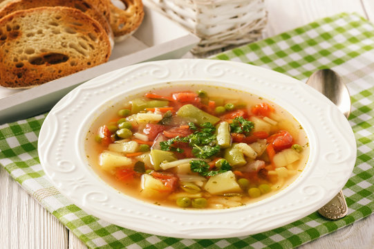 Vegetarian vegetable soup on wooden background.