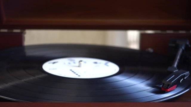 Turntable player,dropping stylus needle on vinyl of a spinning record playing.