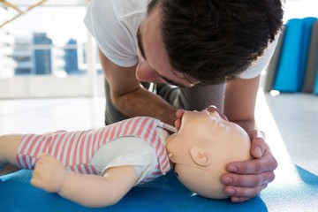 Paramedic practising resuscitation on dummy - Powered by Adobe