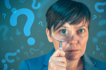 Business woman with question marks looking for answers
