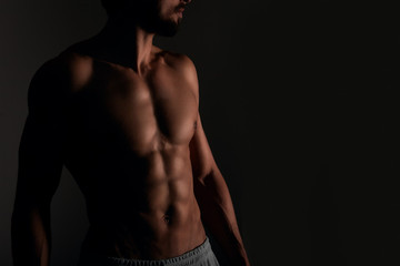 Fototapeta na wymiar Handsome muscular man posing on black background