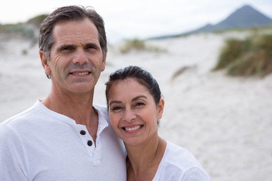 Portrait of happy couple standing on beach