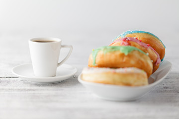 Fresh donuts on tray тв cup of hot espresso