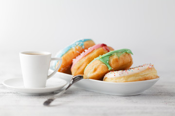Fresh donuts on tray тв cup of hot espresso