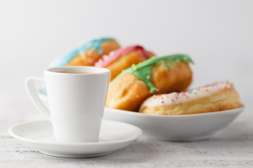 Stack of iced donuts with coffee cup on table