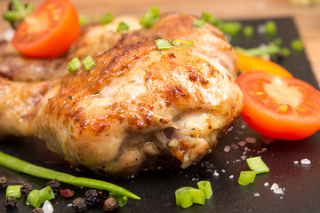 Fried chicken legs garnish cherry tomato and bunch-onion