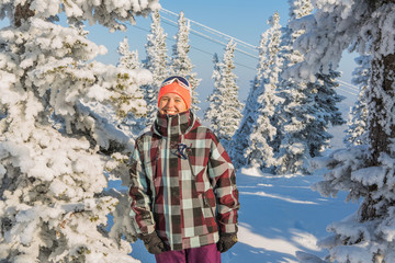 Portrait of young smiling woman near the trees covered with snow