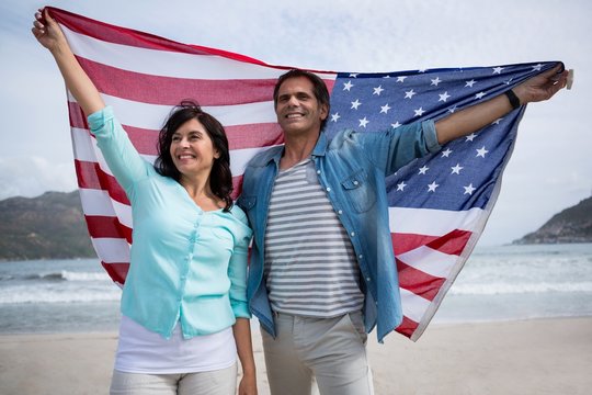 Couple holding American flag on beach