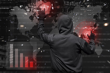 Back view of hooded hacker at work with virtual graphic