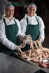 Female butchers processing sausages
