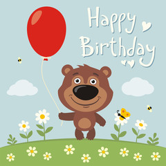 Happy birthday! Funny teddy bear with red balloon on flower meadow. Birthday card with teddy bear in cartoon style.