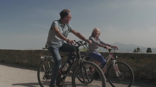 Senior couple cycling on electric bicycles