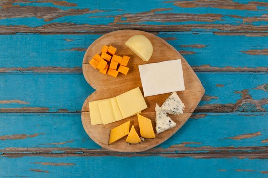 Variety of cheese on heart shaped chopping board