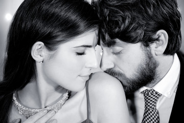 Elegant couple in love man kissing shoulder of girlfriend closeup