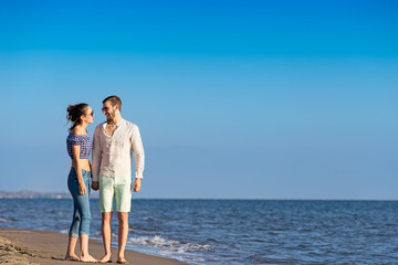 Couple walking on beach. Young happy interracial couple walking on beach.