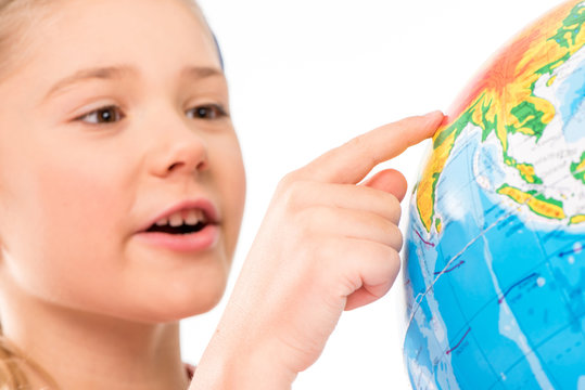 Happy schoolgirl exploring globe