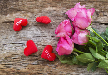 Roses and Red heart pillow on old wooden board, Valentines Day background, wedding day.Postcard / greeting card. Pink roses on textured wooden background. Copy space, top view. Panorama