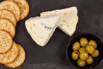 Crispy biscuits, cheese and bowl of green olives