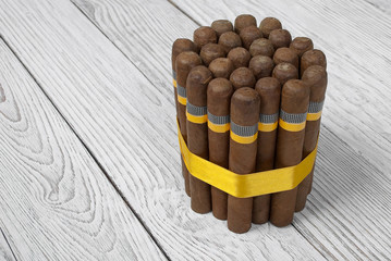 Bunch of Cuban cigars on wooden white  background