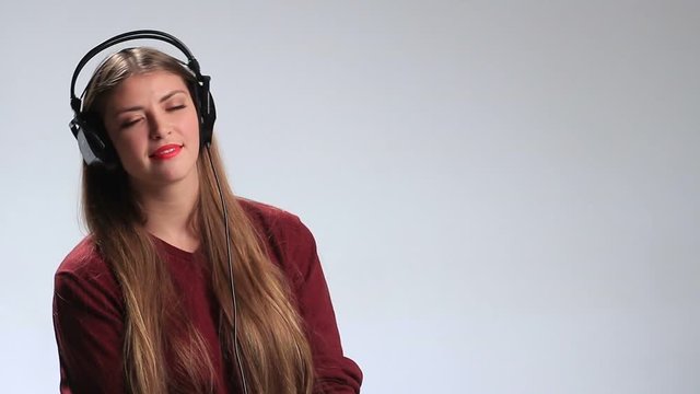 Gorgeous seductive young woman in big headphones