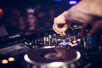 Obraz premium DJ gra muzykę na swojej talii Pioneer na imprezie