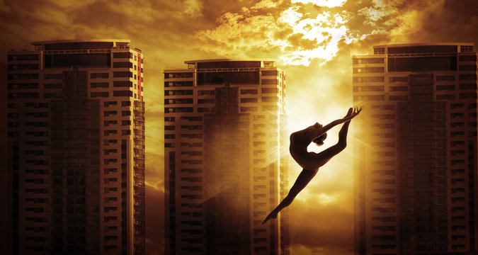 High Rise Building and Sport Woman Dancing Jump, Girl Dancer Silhouette over Apartments House in Sun Light
